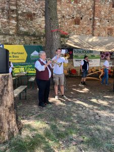 Blasmusikanten spielen auf einer Veranstaltung vor einer Burgruine in Niederösterreich.