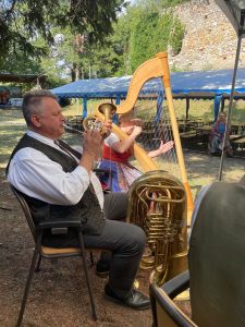 Musiker spielt Trompete mit Harfe und Tuba in der Burgruine Aggstein, Niederösterreich.